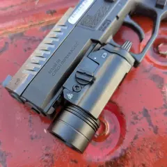 Pistolet CZ z zamontowaną latarką taktyczną, gotowy do akcji. Ta **braun broń** to solidne narzędzie.