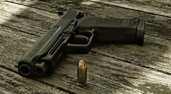 Pistolet HK USP EXPERT z widocznym napisem "45 Auto" obok pocisku. Kaliber pocisku jest kluczowy dla tego modelu.