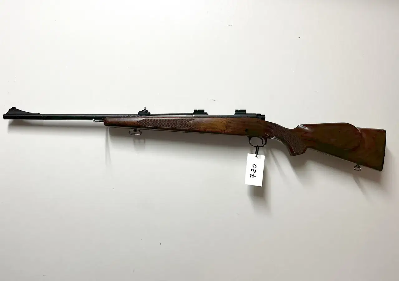 Klasyczny karabin Winchester Model 70 z drewnianą osadą, gotowy do polowania.