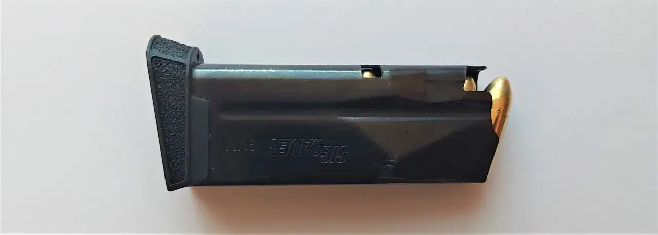 Magazynek broni palnej Sig Sauer 9mm z nabojami.